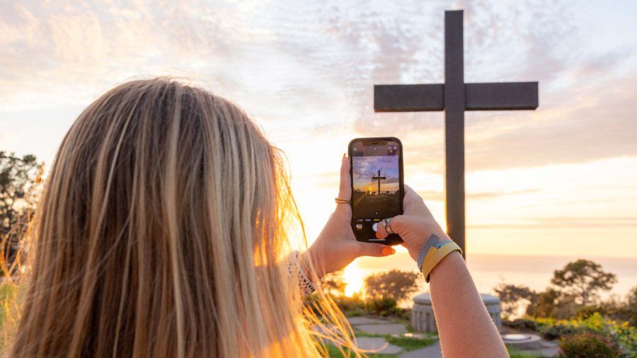 Girl takes photo of the 鶹 cross on campus